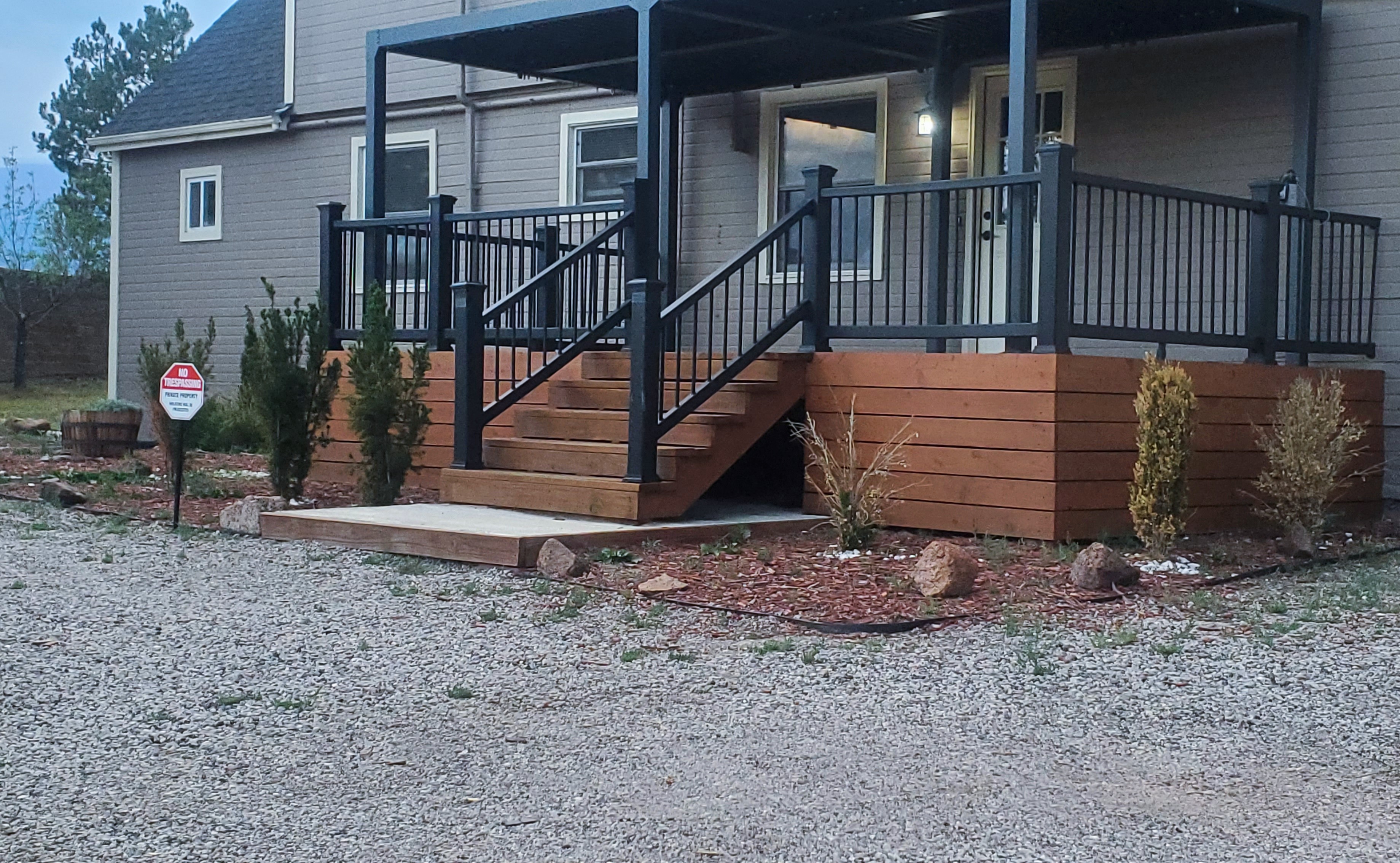 Berglind Rd. property exterior with cedar deck and black railings at dusk