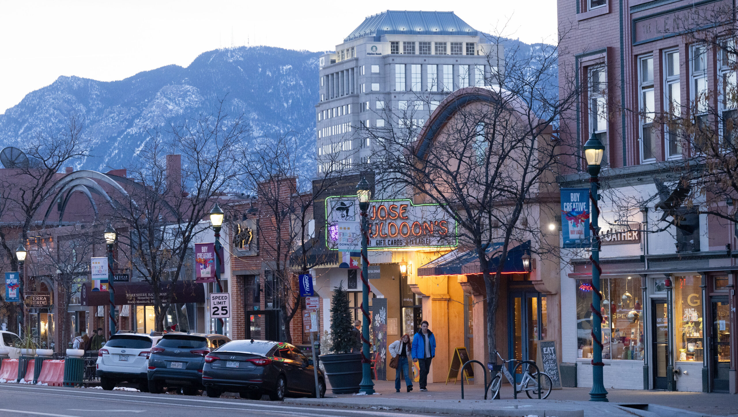 Colorado Springs downtown shopping district at dusk with mountains