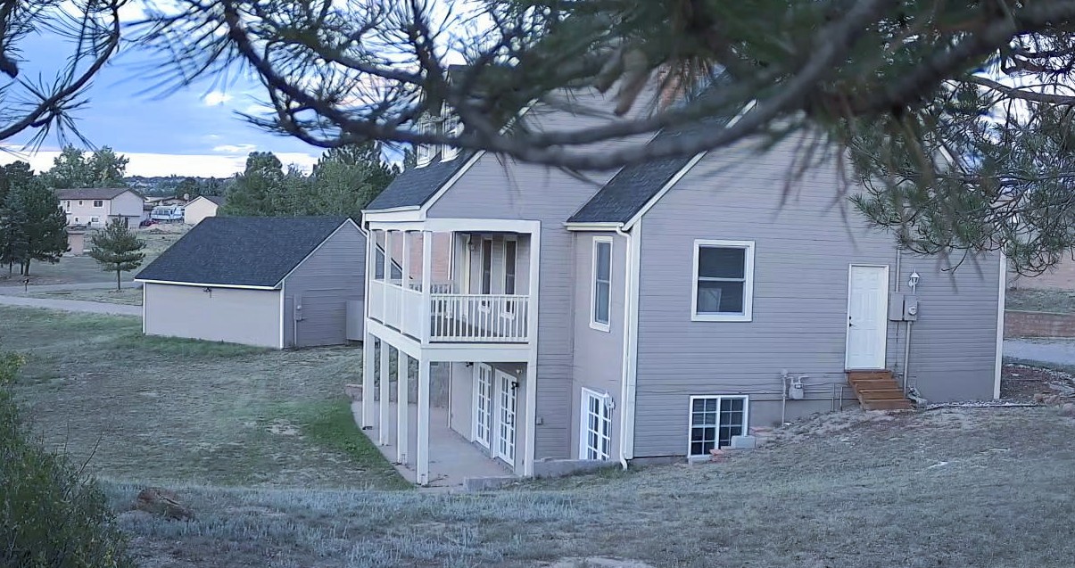 Berglind Rd. property rear view with upper deck and French doors at dusk